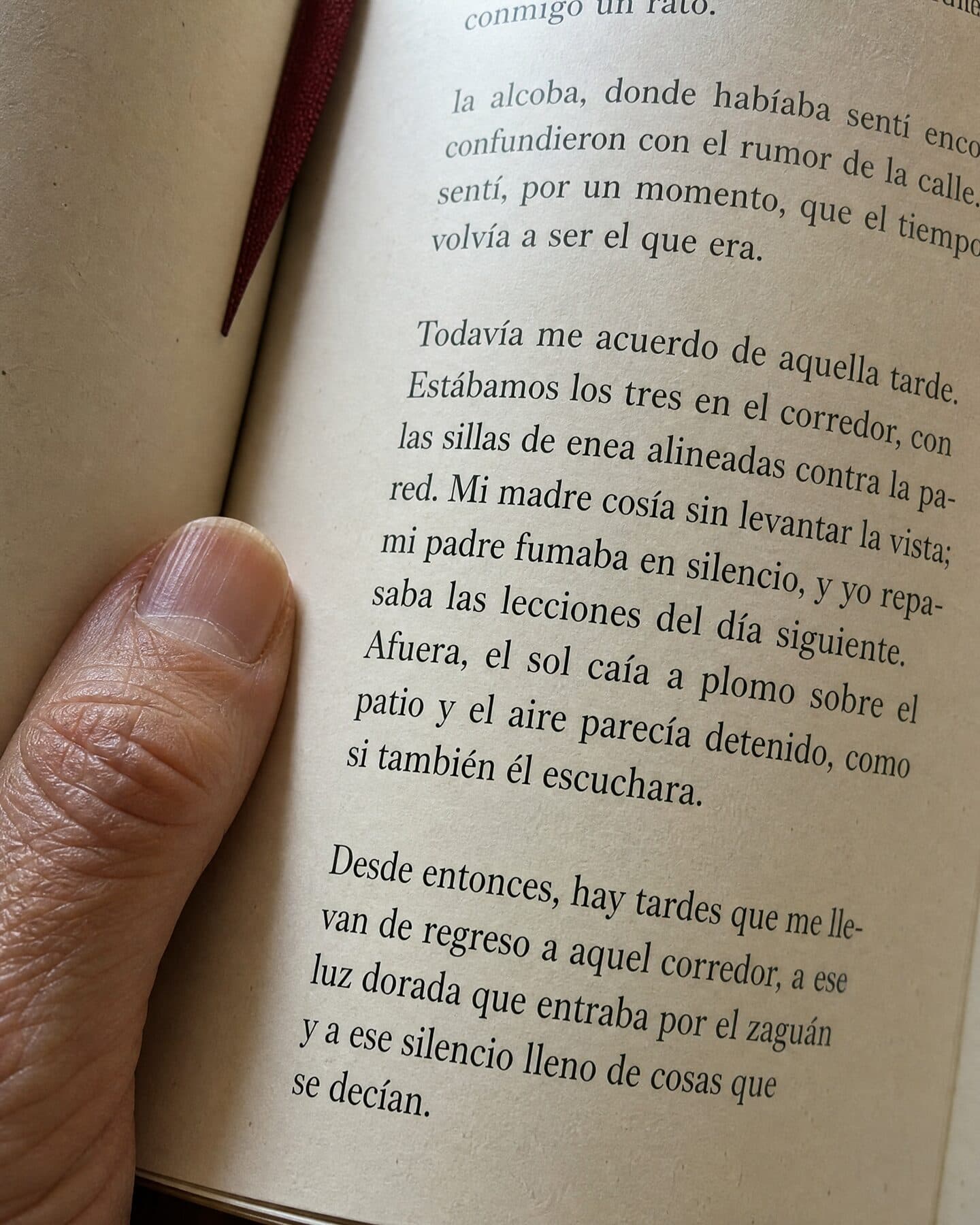 Detalle de una página interior impresa en papel crema con un dedo apoyado en el margen.